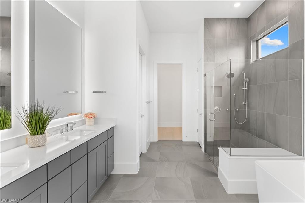 19084 Gentry Place Estero, FL 33928 - Photo 24 of 44 Step-down walk-in shower with tile niche and dual-head shower system