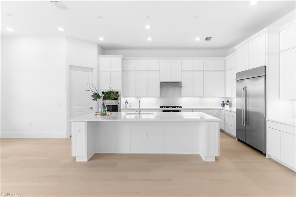 19084 Gentry Place Estero, FL 33928 - Photo 5 of 44 Designer white stacked Winstead cabinetry with built-in stainless appliance package