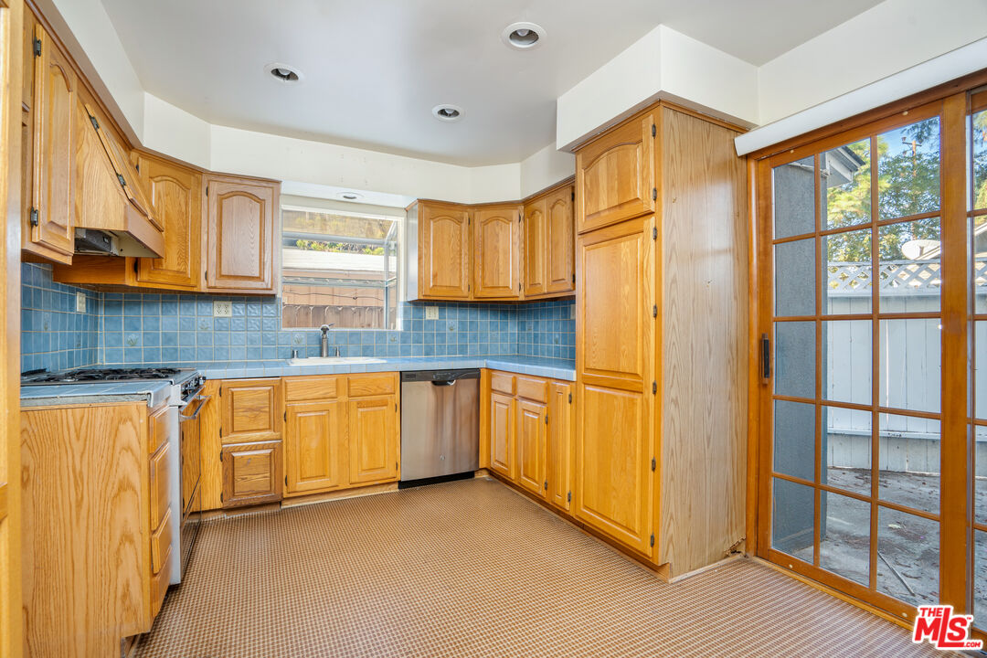 12334 Moorpark Street Studio City, CA 91604 - Photo 15 of 33 a kitchen with granite countertop wooden cabinets a counter top space and stainless steel appliances
