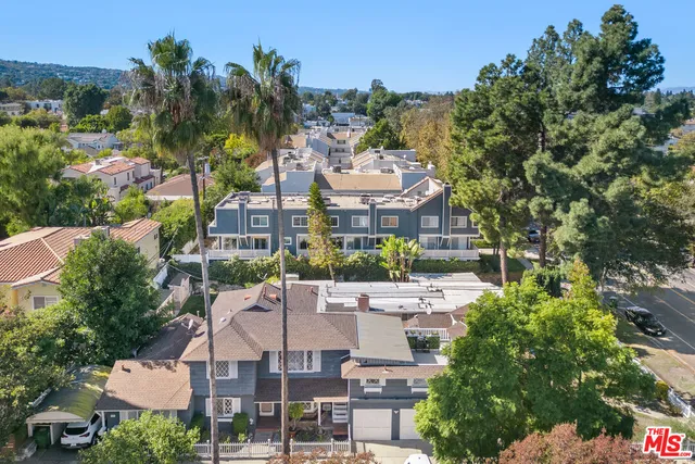 an aerial view of multiple houses with yard