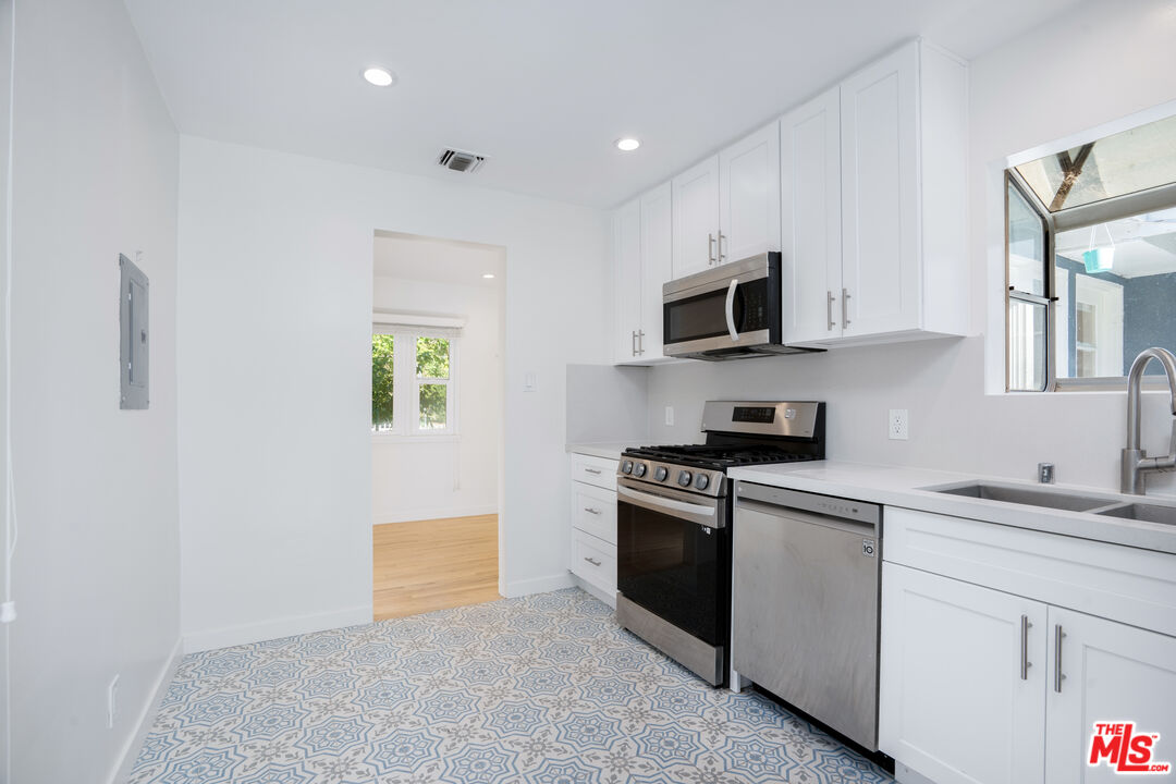 12334 Moorpark Street Studio City, CA 91604 - Photo 33 of 33 a kitchen with granite countertop white cabinets stainless steel appliances and a sink