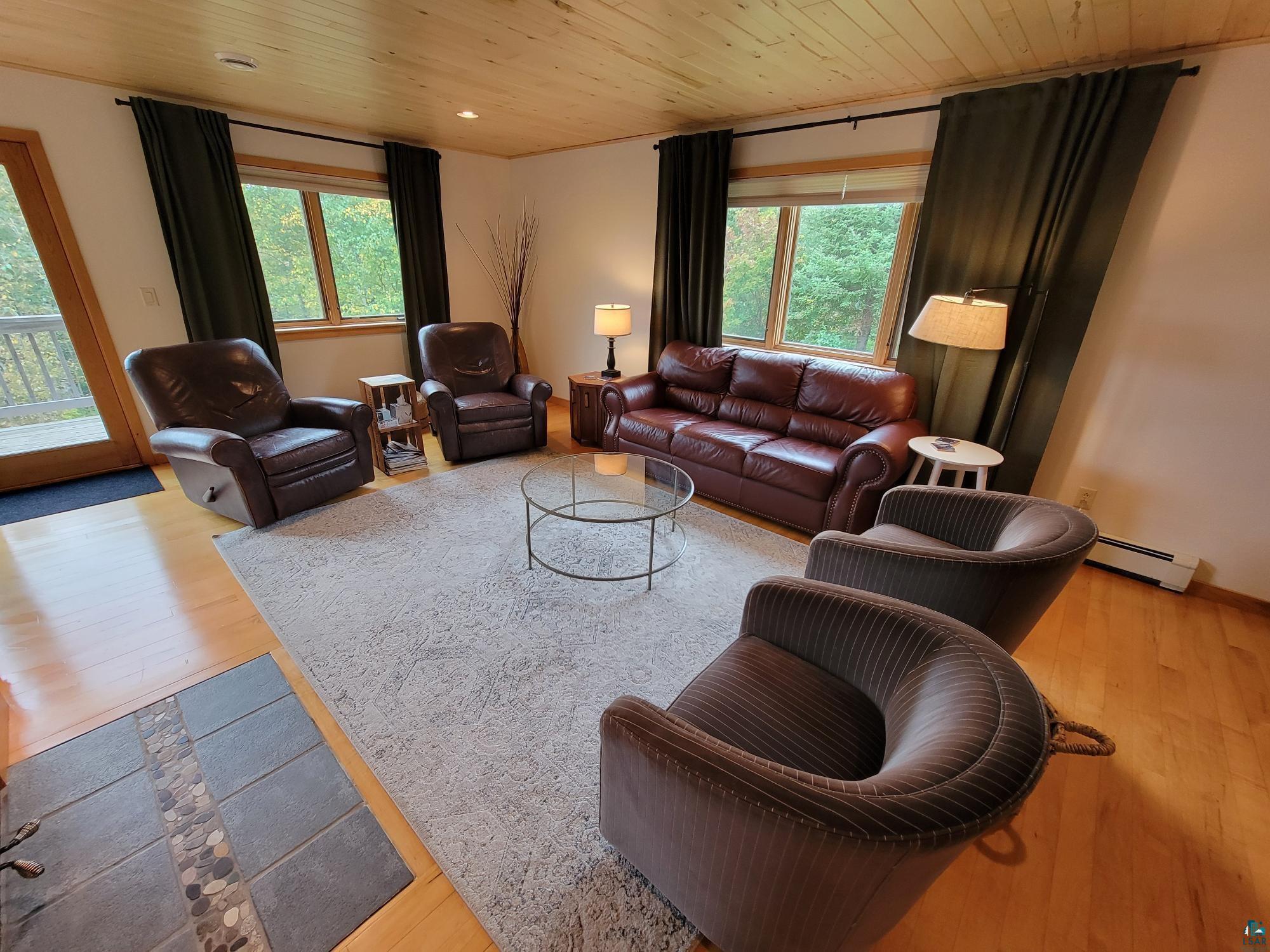 184 Fall River Road Grand Marais, MN 55604 - Photo 16 of 50 Living room featuring a healthy amount of sunlight, a baseboard radiator, and light hardwood / wood-style floors