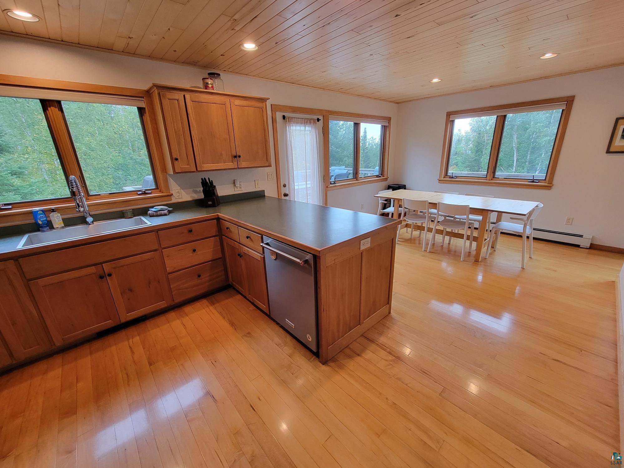 184 Fall River Road Grand Marais, MN 55604 - Photo 25 of 50 Kitchen featuring wooden ceiling, light hardwood / wood-style floors, stainless steel dishwasher, kitchen peninsula, and sink