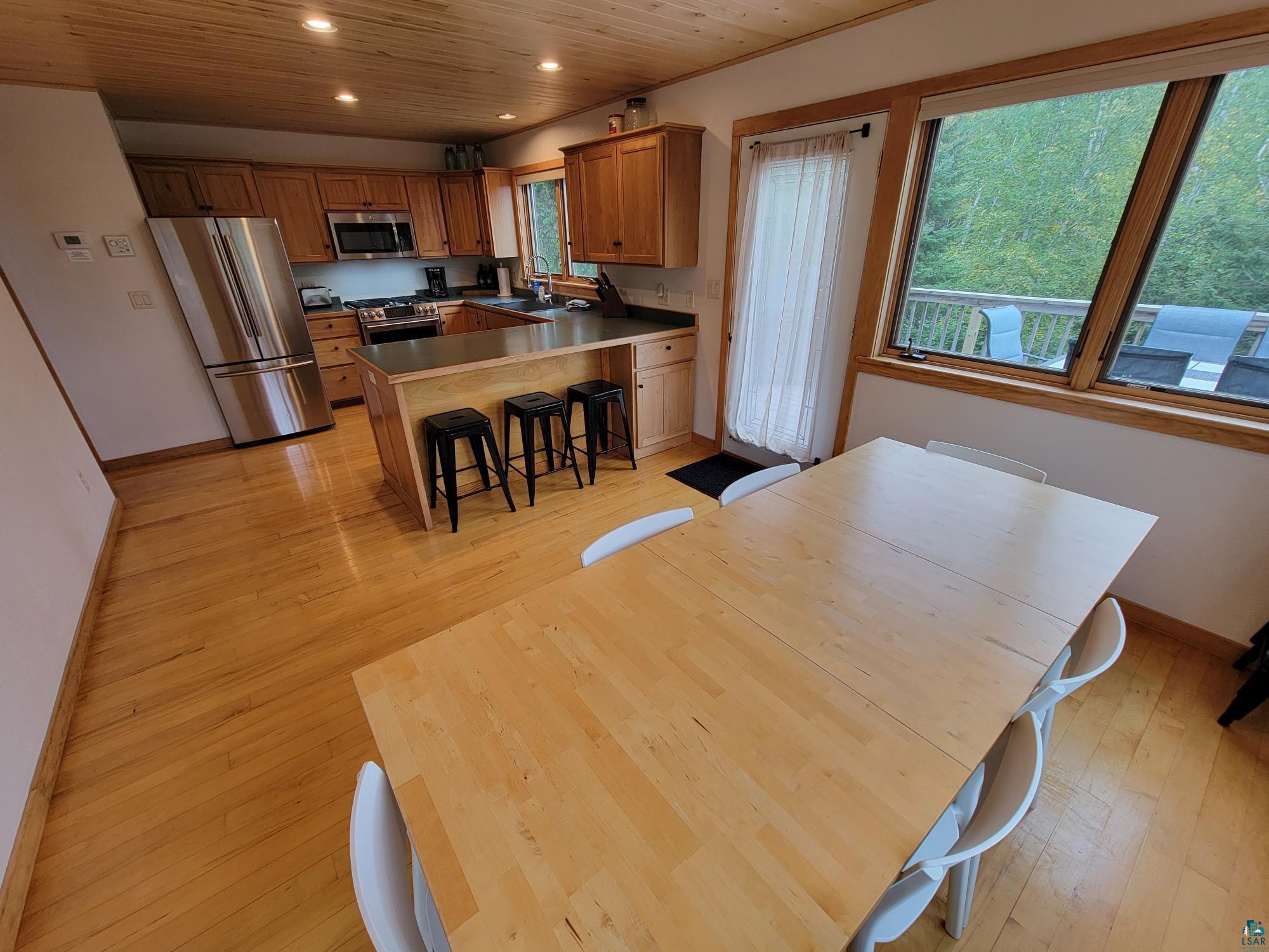184 Fall River Road Grand Marais, MN 55604 - Photo 26 of 50 Dining room featuring wood ceiling, light hardwood / wood-style flooring, and sink