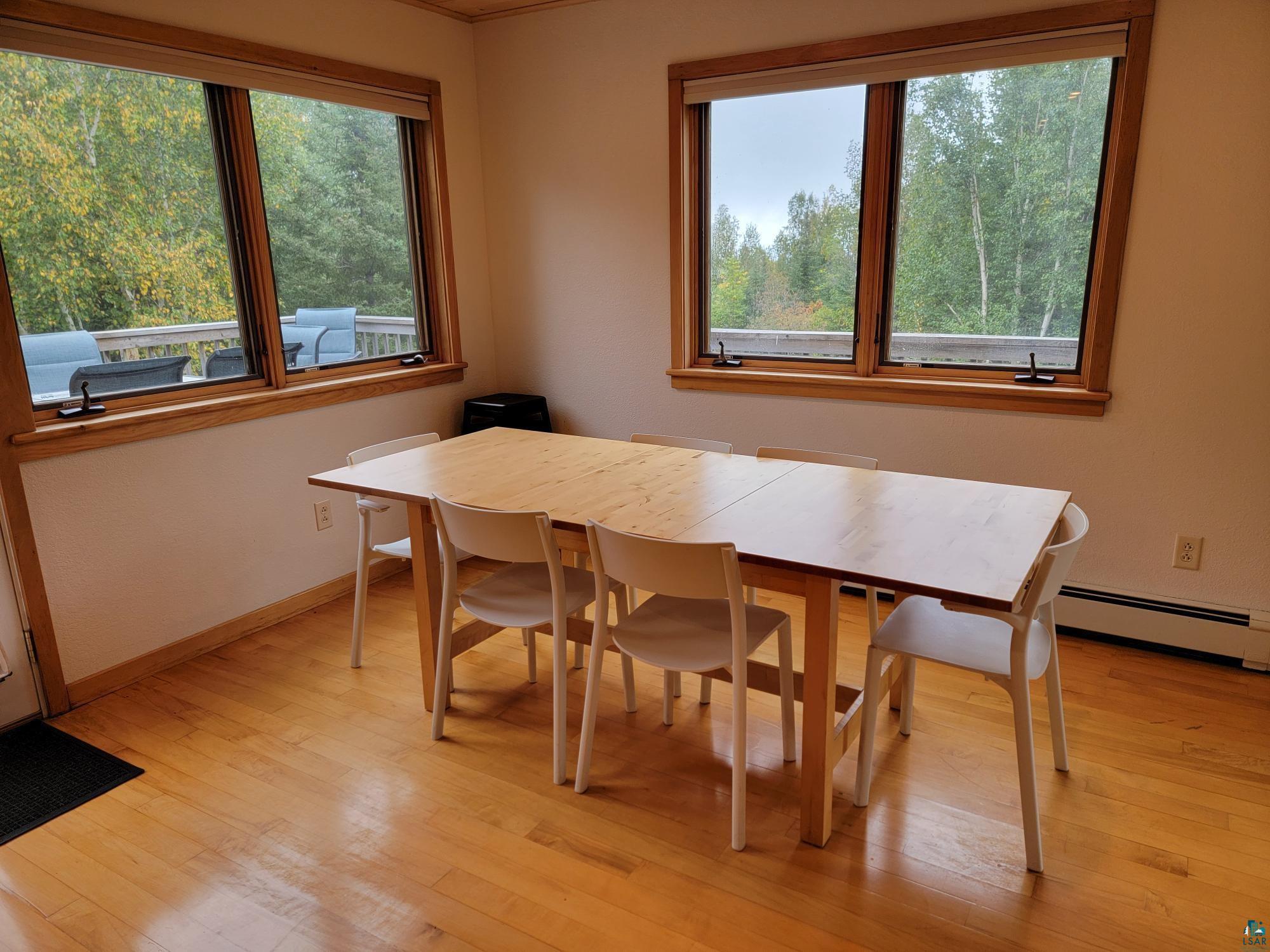 184 Fall River Road Grand Marais, MN 55604 - Photo 27 of 50 Dining space featuring a baseboard radiator, plenty of natural light, and light hardwood / wood-style flooring