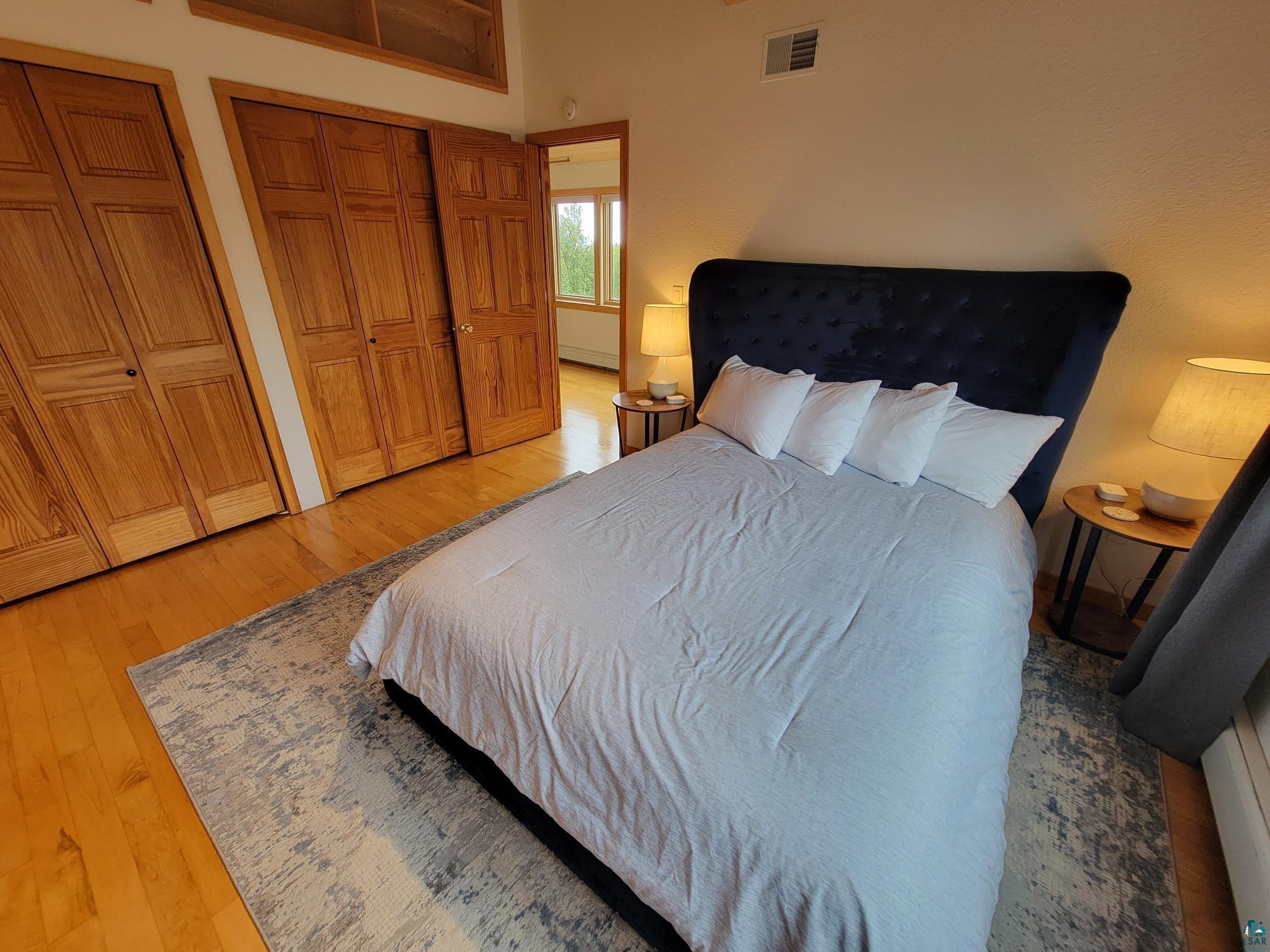 184 Fall River Road Grand Marais, MN 55604 - Photo 28 of 50 Bedroom with hardwood / wood-style floors and multiple closets