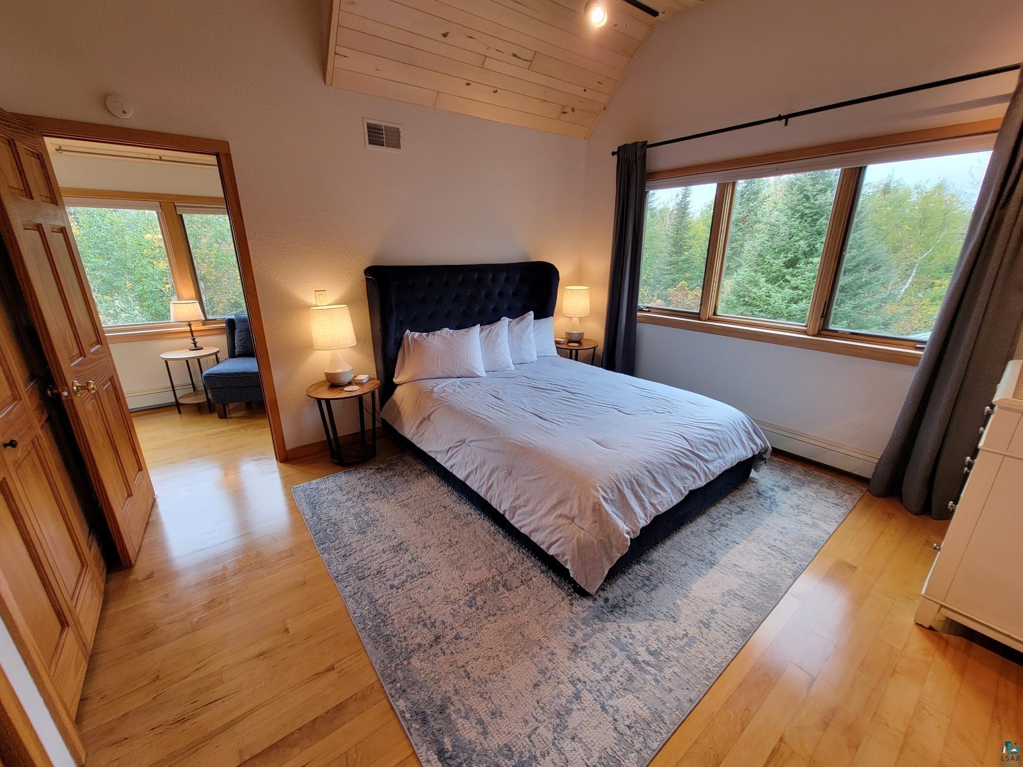 184 Fall River Road Grand Marais, MN 55604 - Photo 29 of 50 Bedroom with multiple windows, lofted ceiling, wood ceiling, and light hardwood / wood-style floors