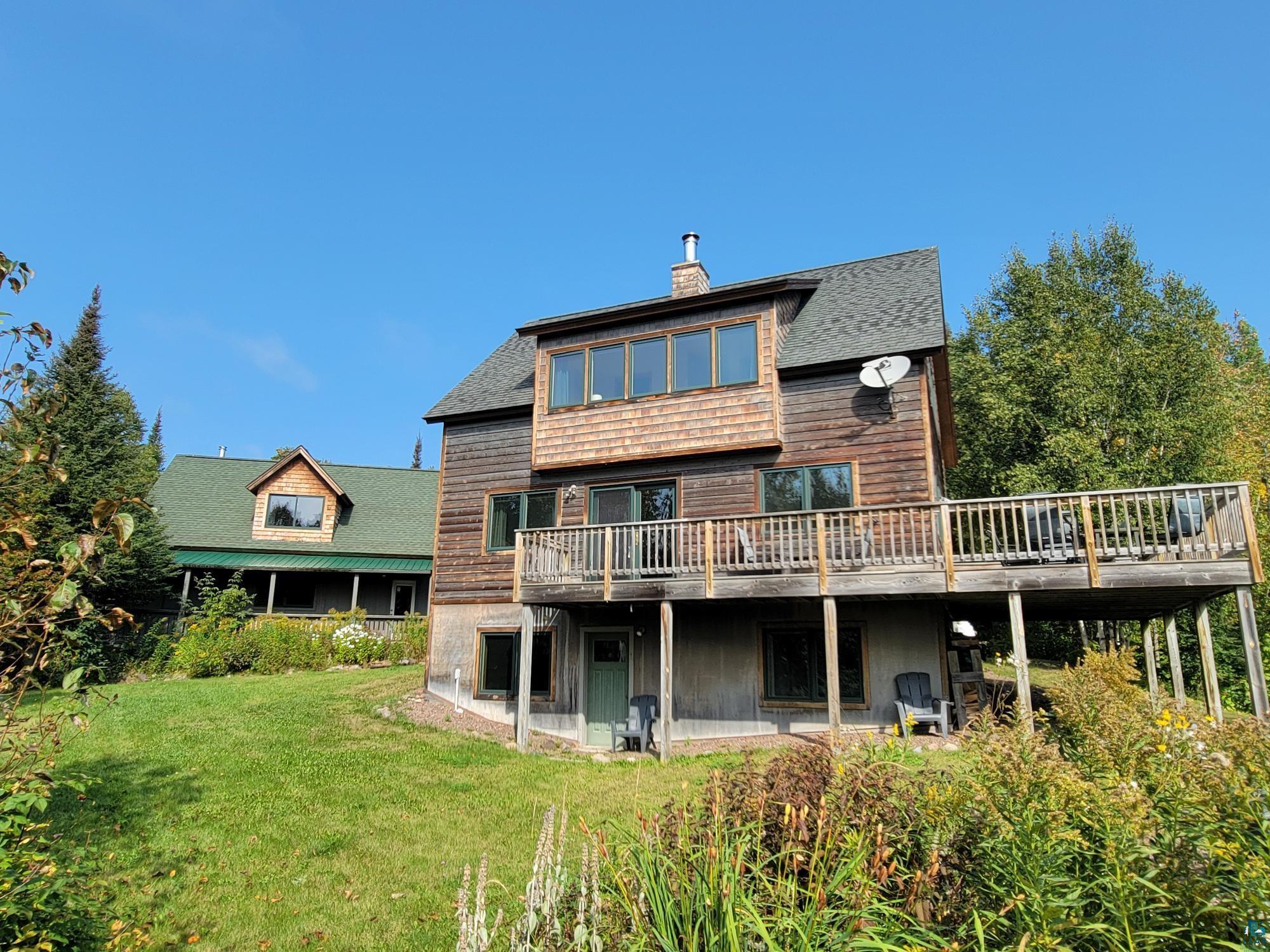 184 Fall River Road Grand Marais, MN 55604 - Photo 3 of 50 Rear view of house with a wooden deck and a lawn