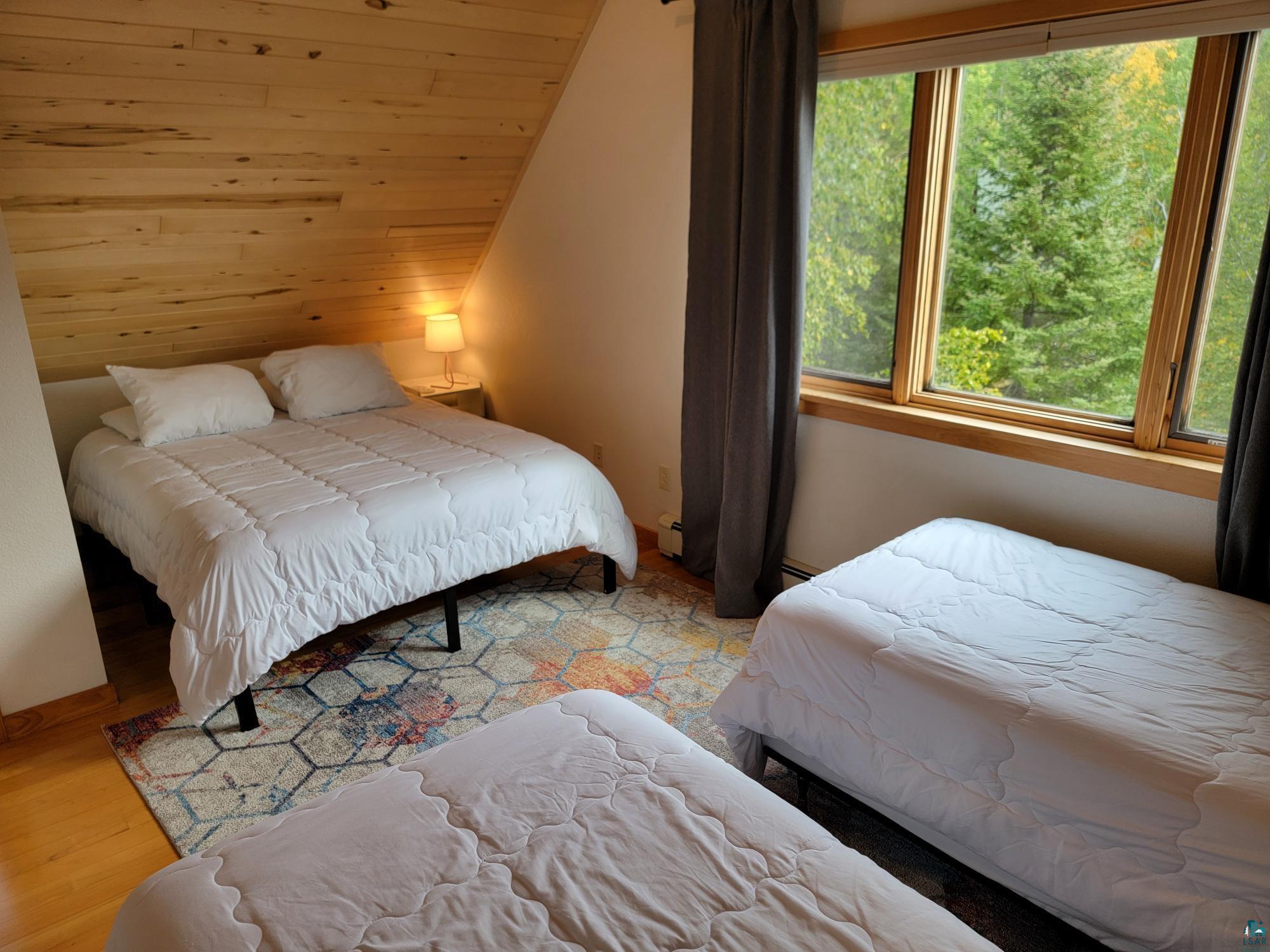 184 Fall River Road Grand Marais, MN 55604 - Photo 34 of 50 Bedroom featuring multiple windows and light hardwood / wood-style flooring