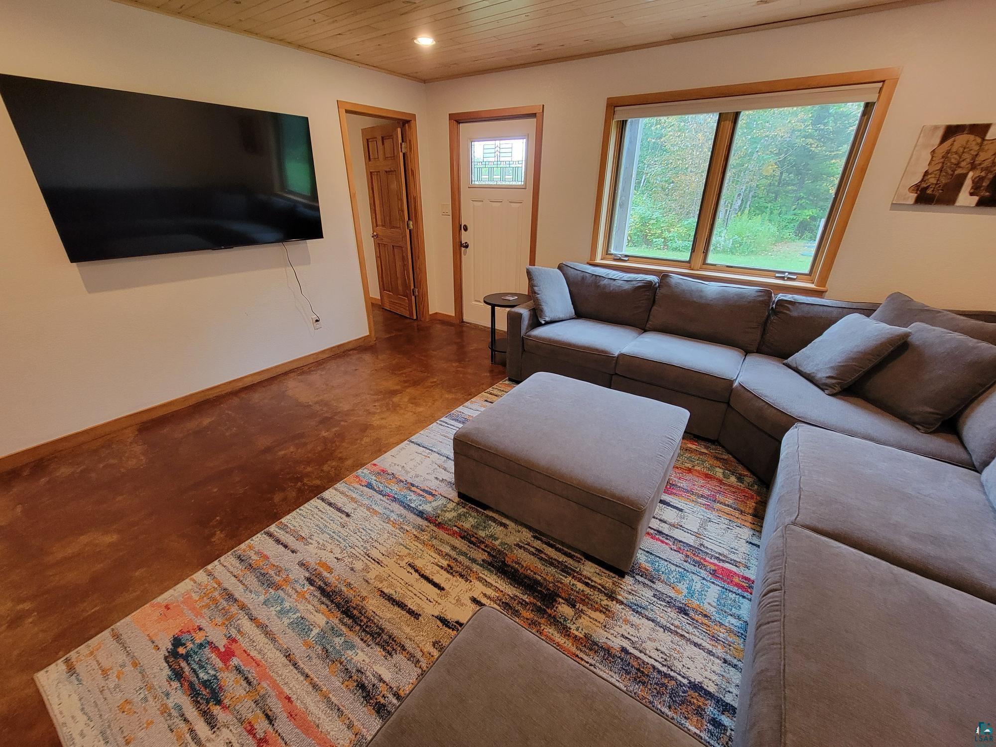184 Fall River Road Grand Marais, MN 55604 - Photo 38 of 50 Living room with dark colored carpet and wooden ceiling