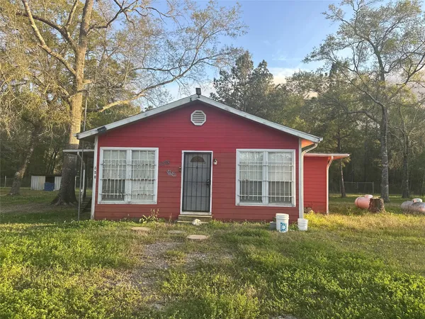 a view of brick house with a yard