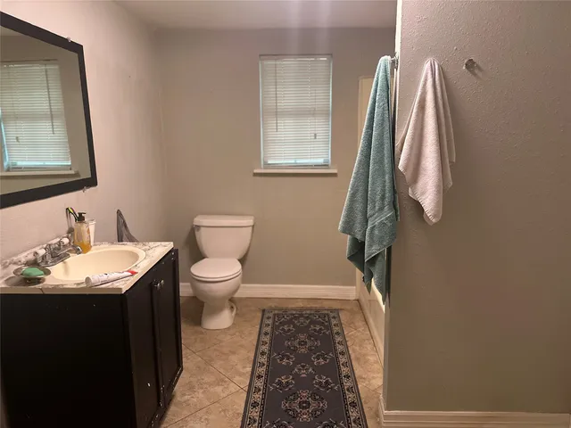 a bathroom with a sink toilet and a mirror