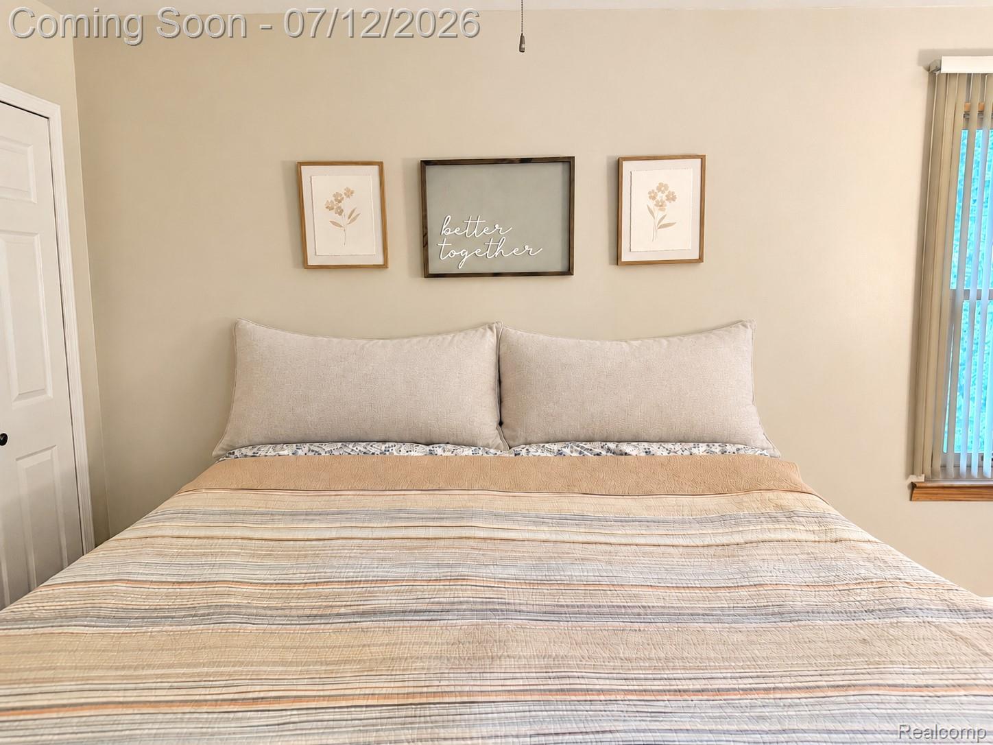 2033 Avonstoke Road Rochester, MI 48307 - Photo 8 of 26 Neutral-toned wall space featuring a window with vertical blinds and a white paneled door with black hardware