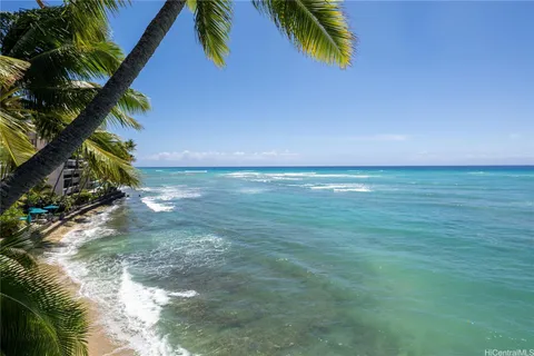 a view of a swimming pool with a chair and tables in the patio