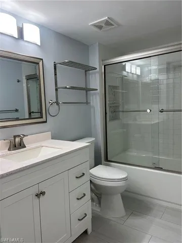 a view of an empty room with wooden floor and closet