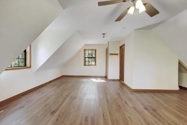 a view of an empty room with wooden floor and closet