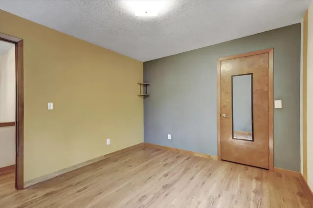 a view of a backyard with large trees and wooden fence