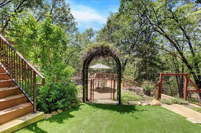 a view of a backyard with chairs and potted plants
