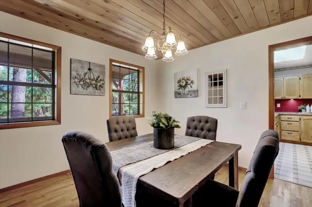 a spacious bedroom with a bed couch chandelier and a window