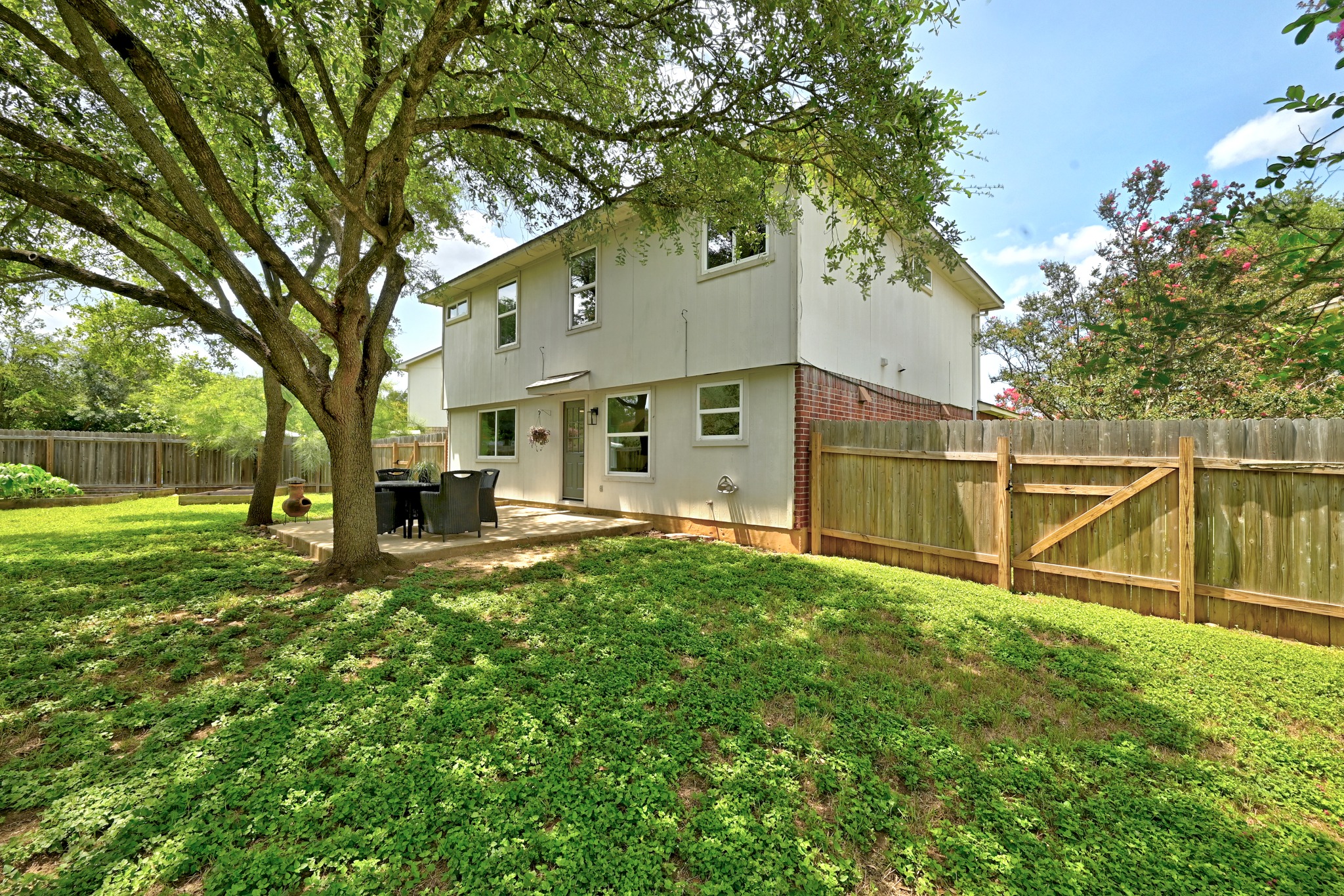 1801 Monks Tale Court Austin, TX 78748 - Photo 28 of 36 A spacious yard boasts a paved patio for outdoor dining, shaded by mature trees.