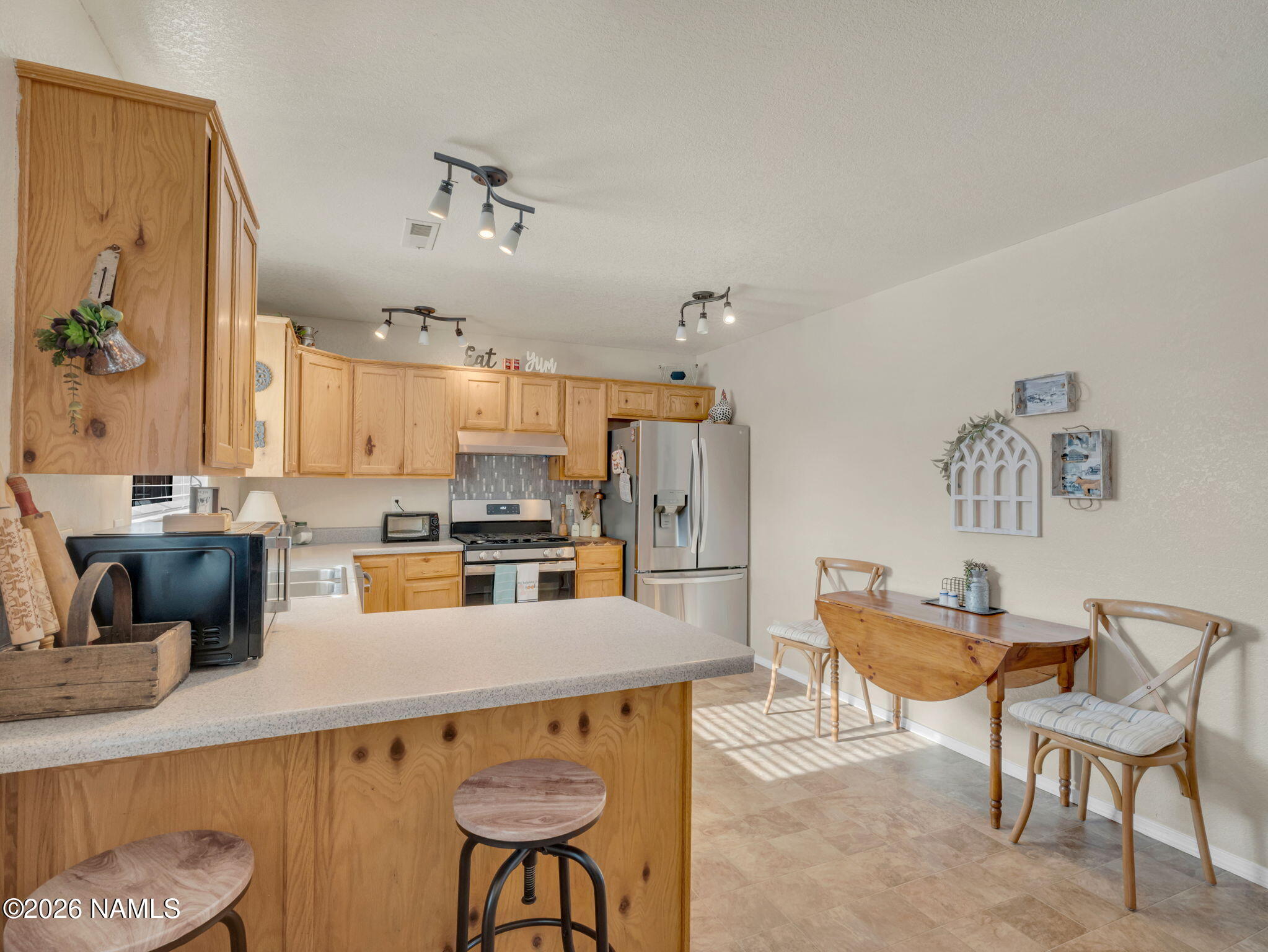1105 West Morse Avenue Williams, AZ 86046 - Photo 8 of 26 a kitchen with a table chairs and a refrigerator