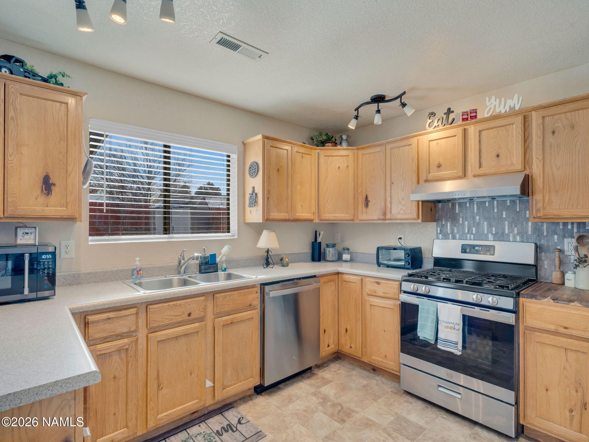 1105 West Morse Avenue Williams, AZ 86046 - Photo 9 of 26 a kitchen with stainless steel appliances granite countertop a sink stove and cabinets