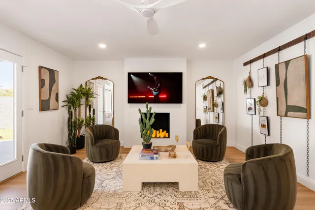 a living room with furniture a flat screen tv and a floor to ceiling window