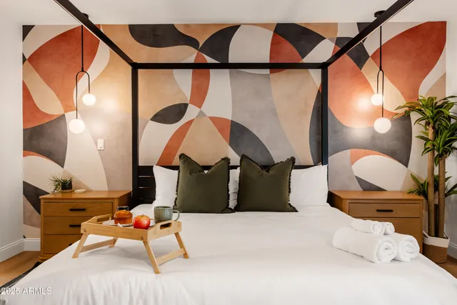 a bedroom with a bed and lamp with the bathroom