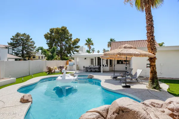 a view of a house with swimming pool and sitting area