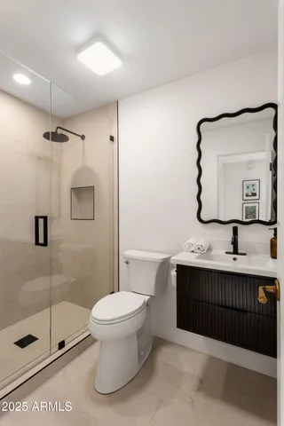 a bathroom with a toilet a sink and mirror