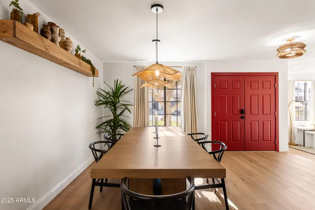 a dining room with furniture potted plants and wooden floor