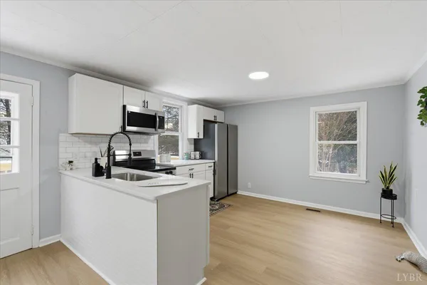 a kitchen with kitchen island white cabinets and appliances