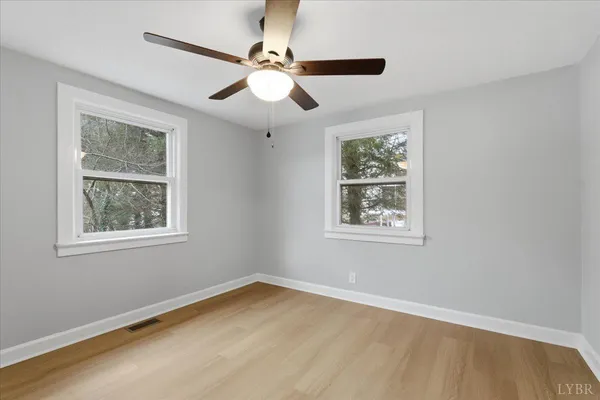 a view of a house with a yard chairs and wooden fence