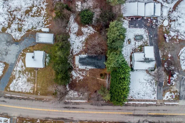 an aerial view of a house with a yard and large tree