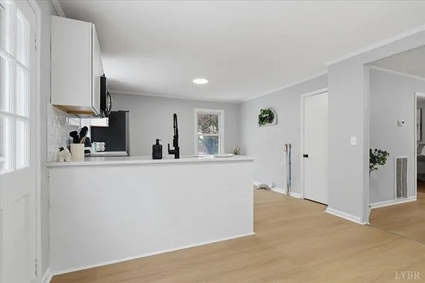 a kitchen with kitchen island white cabinets and appliances