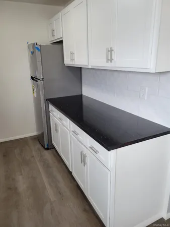 a kitchen with granite countertop white cabinets and white appliances