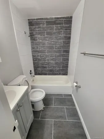 a bathroom with a granite countertop bathtub toilet and sink
