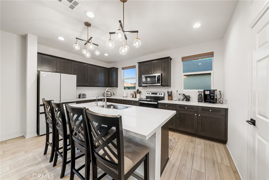 a kitchen with a dining table chairs stainless steel appliances and cabinets