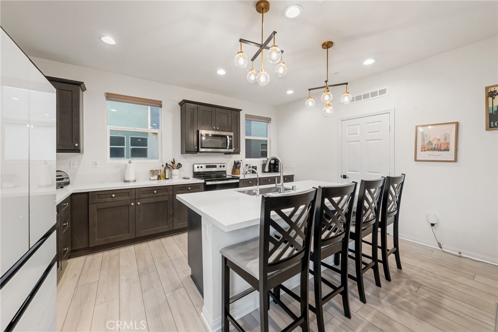 329 North Standard Avenue Santa Ana, CA 92701 - Photo 7 of 34 a kitchen with a table chairs microwave and cabinets