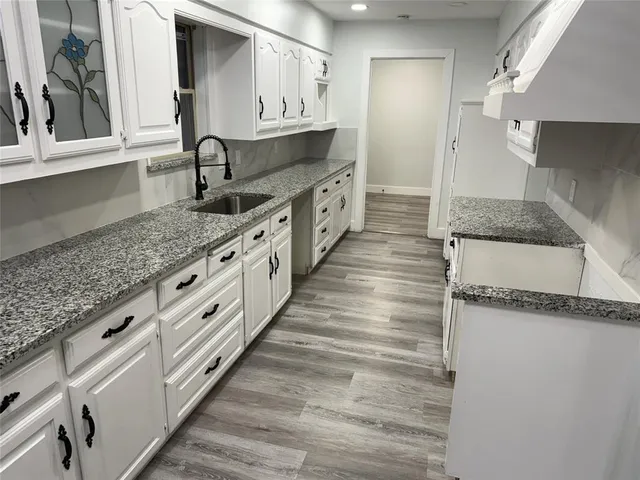 a kitchen with granite countertop a sink and a stove