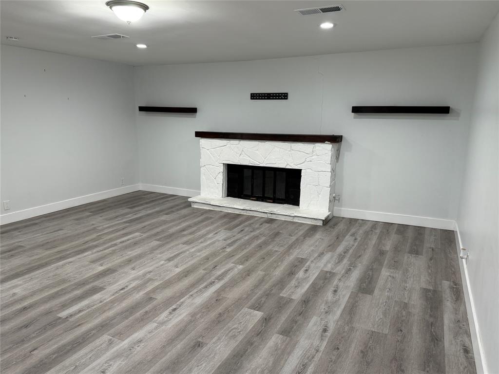 2847 West Rochelle Road Irving, TX 75062 - Photo 6 of 14 a view of an empty room with wooden floor and a fireplace