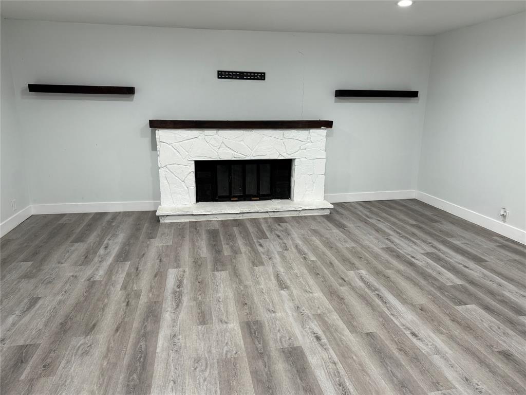 2847 West Rochelle Road Irving, TX 75062 - Photo 8 of 14 a view of an empty room with wooden floor and a fireplace