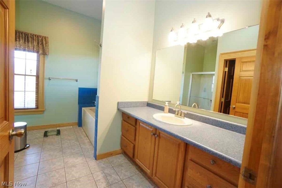 9835 Kile Road Chardon, OH 44024 - Photo 17 of 40 Bathroom with tile flooring, vanity with extensive cabinet space, and a bath to relax in