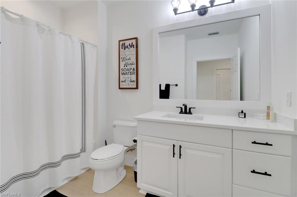 451 Bayfront Place, Unit 5505 Naples, FL 34102 - Photo 12 of 23 a bathroom with a toilet sink and mirror