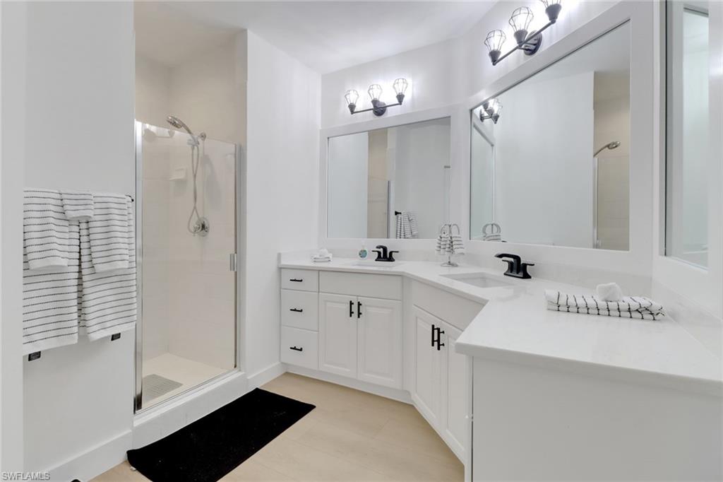 451 Bayfront Place, Unit 5505 Naples, FL 34102 - Photo 10 of 23 a spacious bathroom with a shower a sink and a mirror