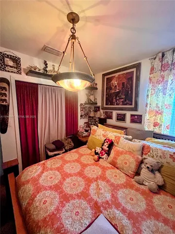 a bed sitting in a bedroom and painting on the wall