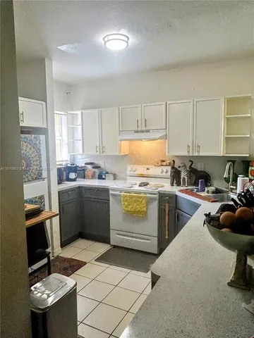 a kitchen with a sink appliances cabinets and a counter top space
