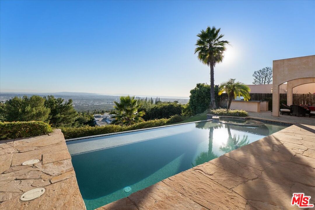1740 Carla Ridge Beverly Hills, CA 90210 - Photo 14 of 36 a view of swimming pool with a table and chairs