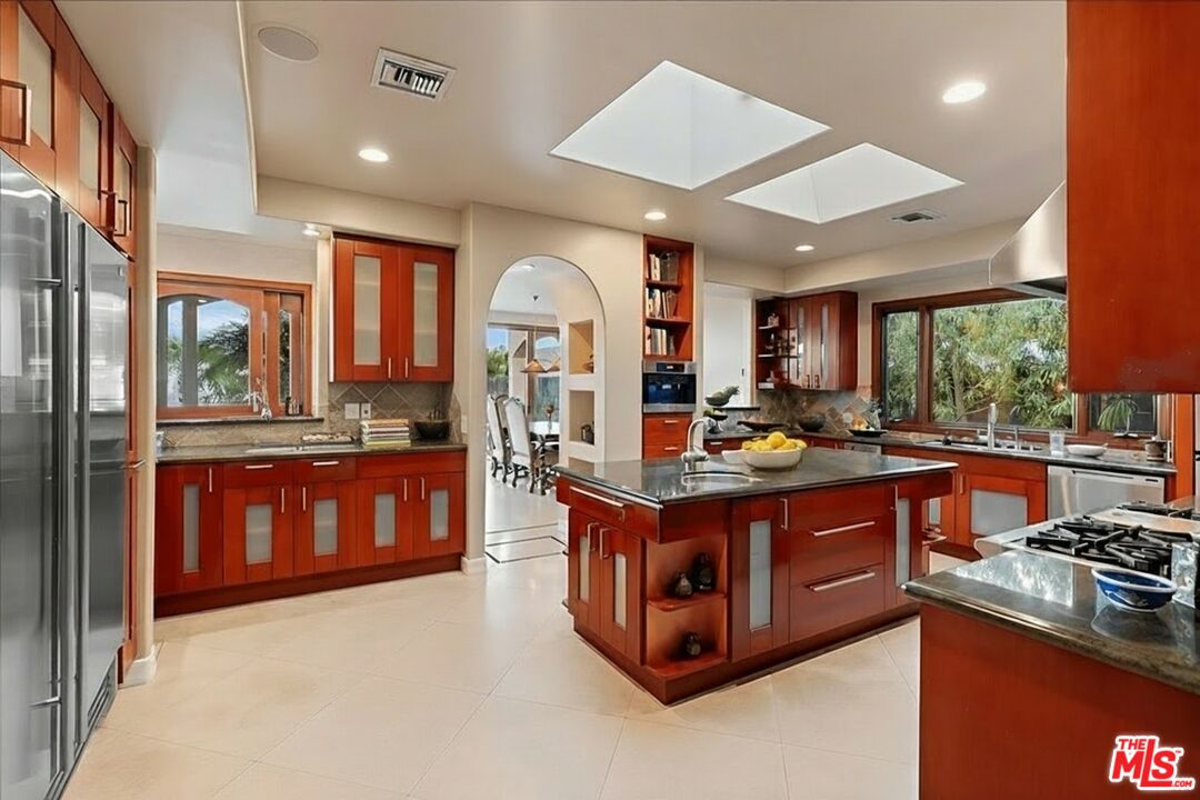 1740 Carla Ridge Beverly Hills, CA 90210 - Photo 22 of 36 a kitchen with stainless steel appliances granite countertop a stove and a large refrigerator