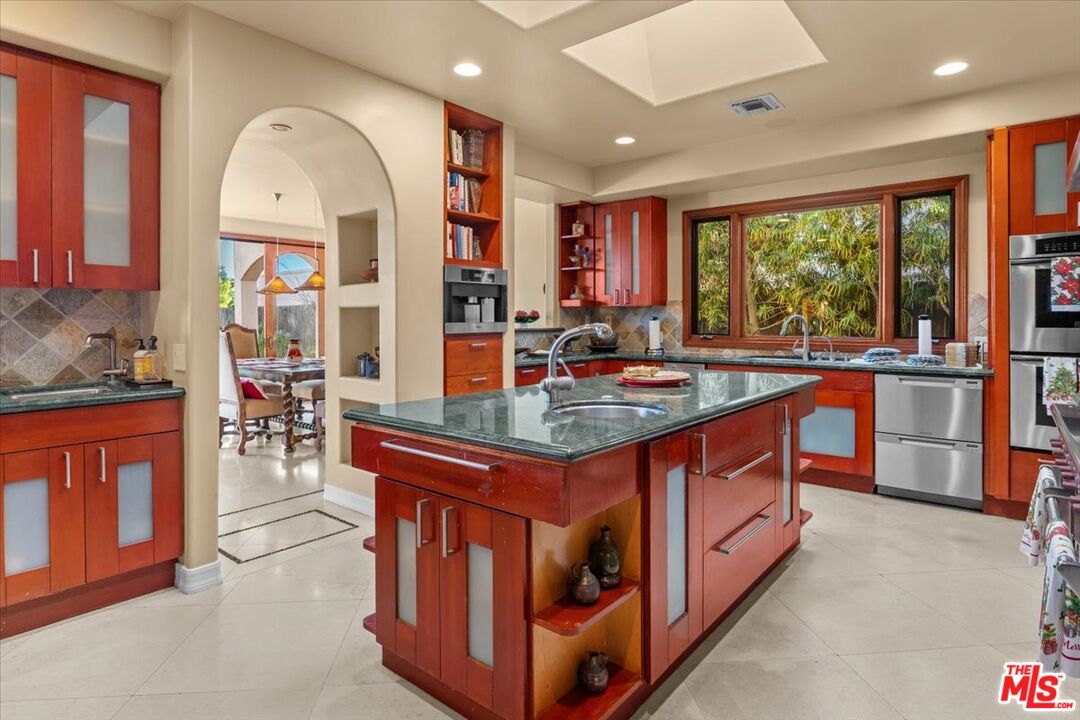 1740 Carla Ridge Beverly Hills, CA 90210 - Photo 23 of 36 a kitchen with stainless steel appliances granite countertop a stove and large window